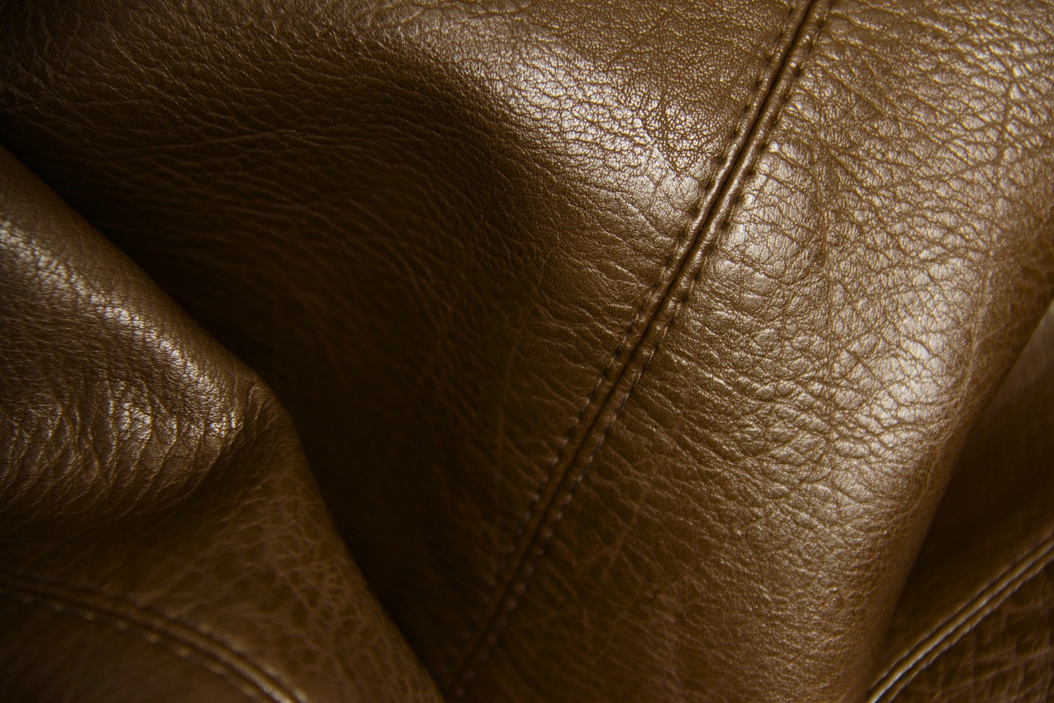Macro detail of caramel leather upholstery and joinery hardware