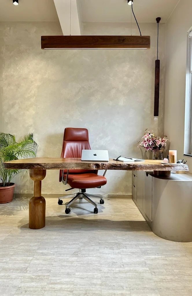 The live-edge oak table and leather chair at the Inchscale studio in Aundh, Pune